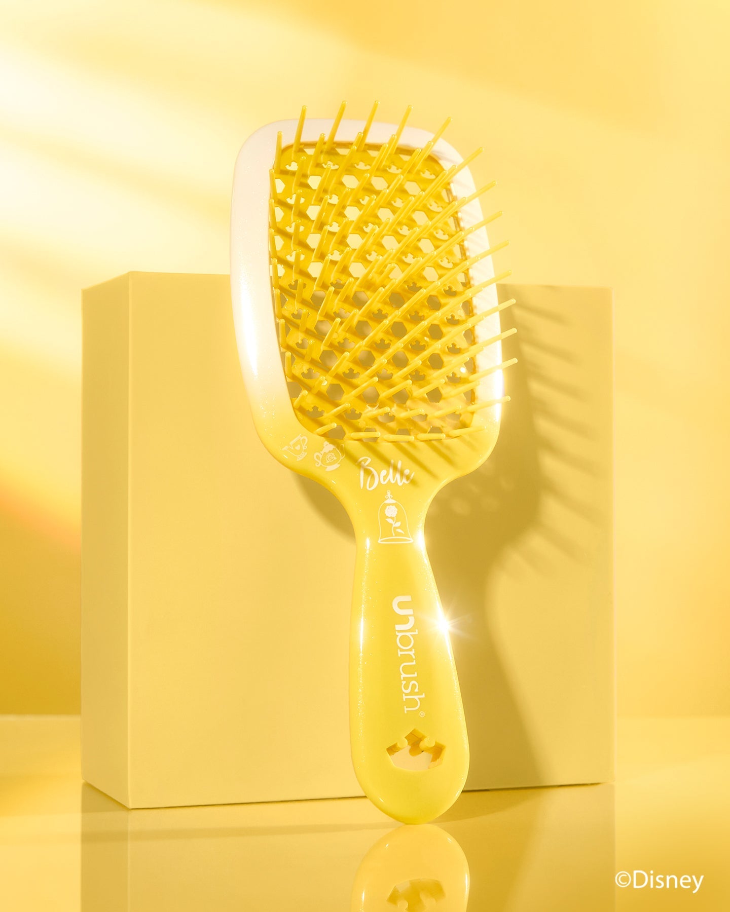 Yellow hairbrush with a box on a yellow background