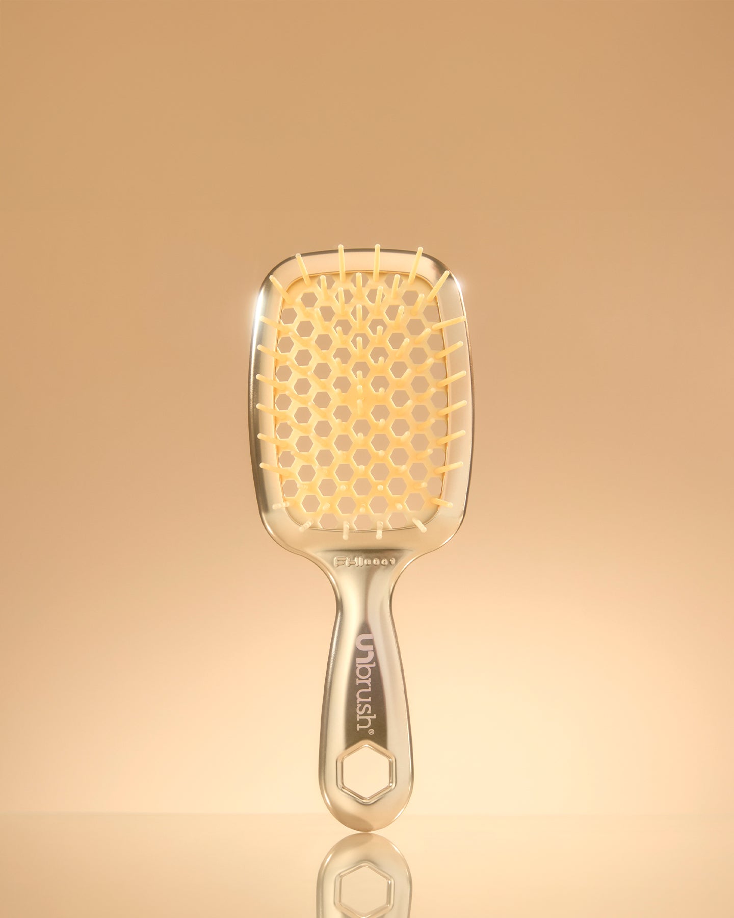 Gold hairbrush on a gold gradient background