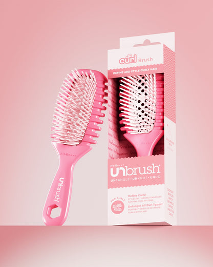 Pink hairbrush with packaging on a pink background