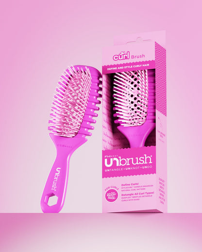Pink hairbrush with packaging on a pink background
