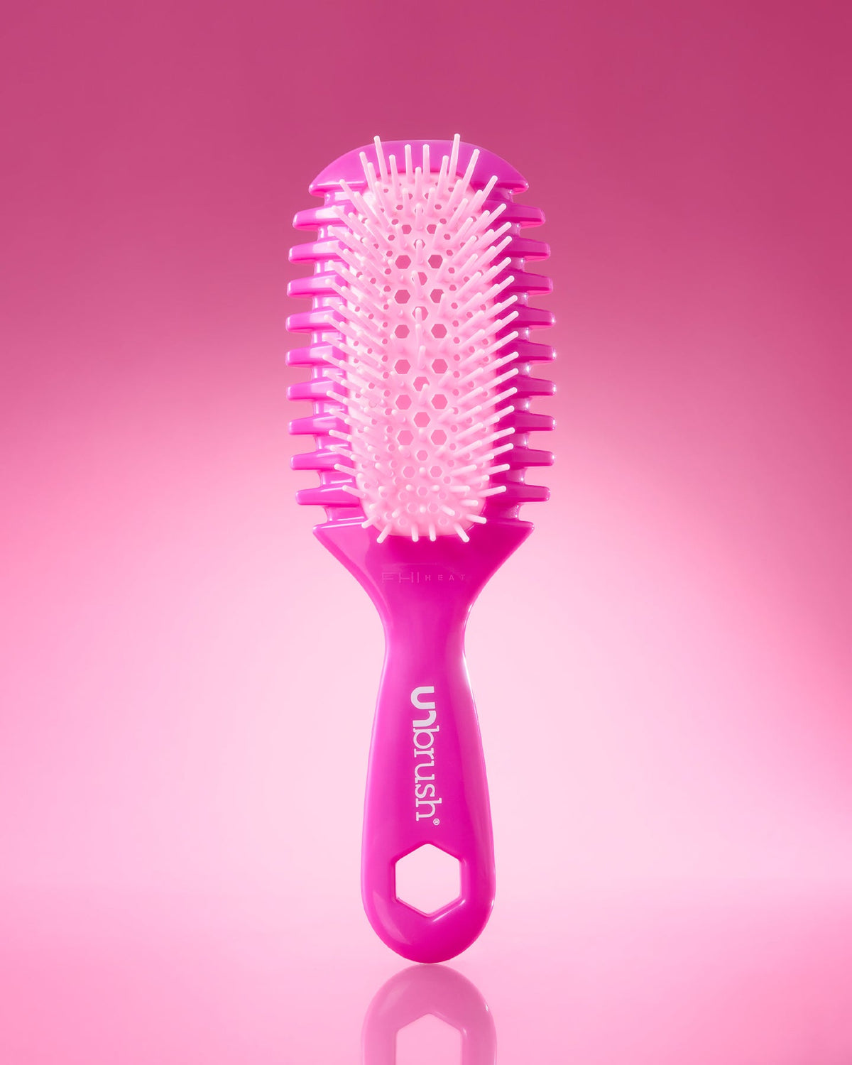 Pink hairbrush with 'unbrush' branding on a pink background