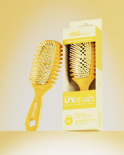 Yellow hairbrush with packaging on a yellow background