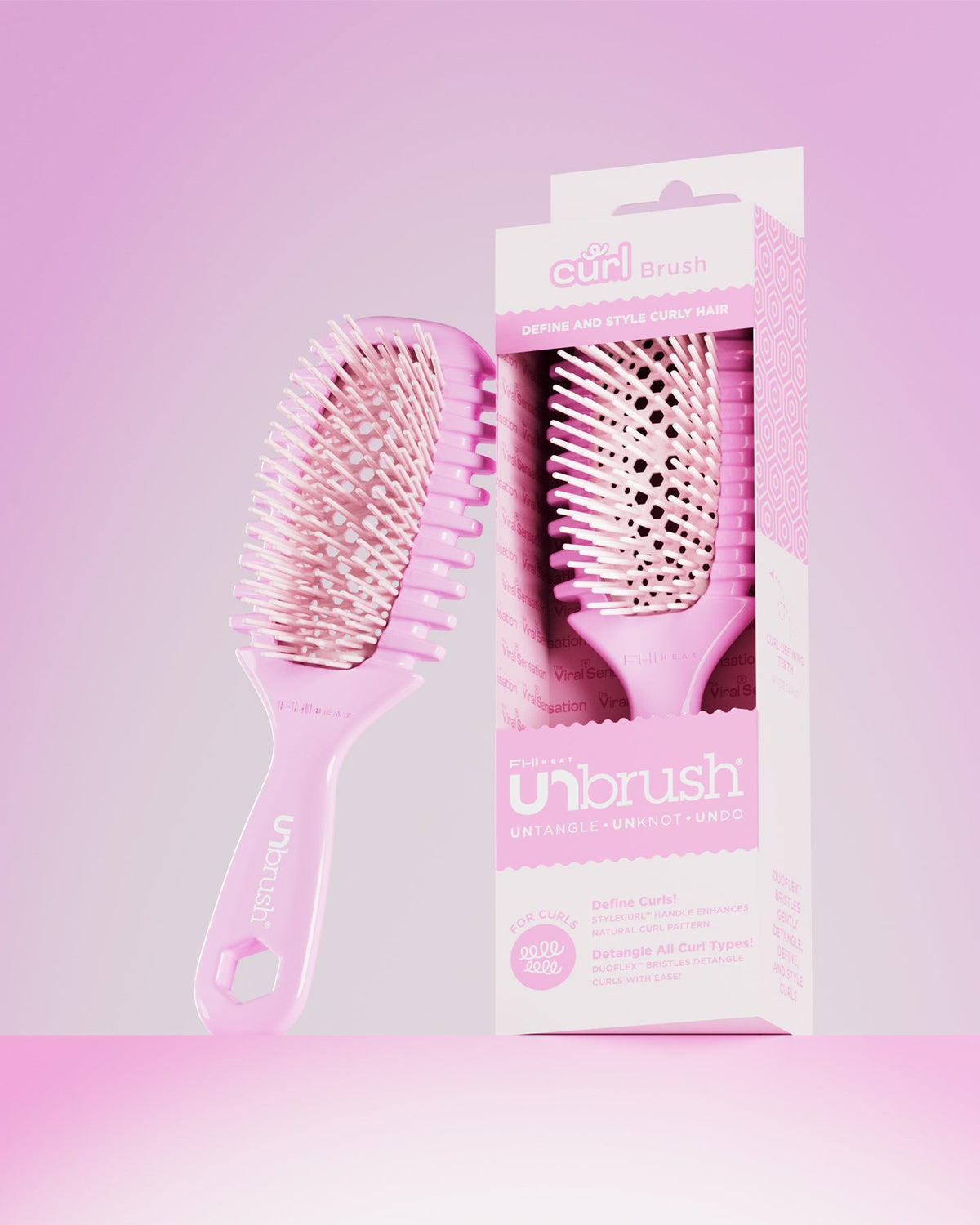 Pink hairbrush with packaging on a pink gradient background