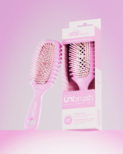 Pink hairbrush with packaging on a pink gradient background