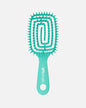 Front image of teal UNbrush hairbrush with flexible spiral bristles and a hexagonal hole in the handle, shown on a off-white background.