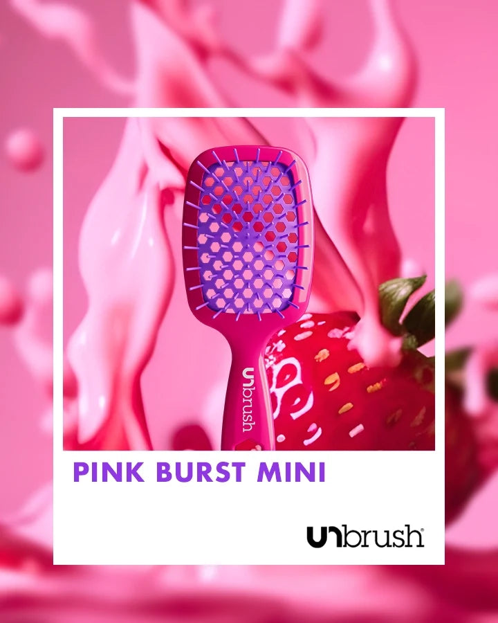 “Pink Burst” Unbrush Mini with vibrant purple hexagon bristles and vibrant pink handle, styled against light fruit background.